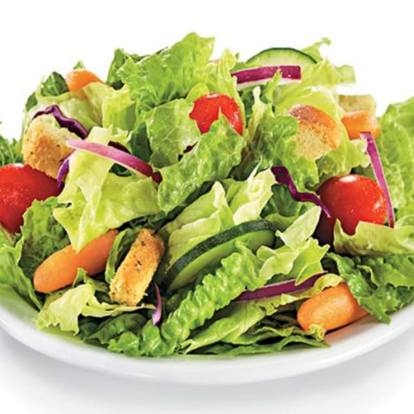 Fresh garden salad with lettuce, tomatoes, cucumbers, red onions, carrots, and croutons.